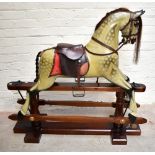 A 20th century rocking horse on pine base with applied brass label inscribed 'New Market Secret
