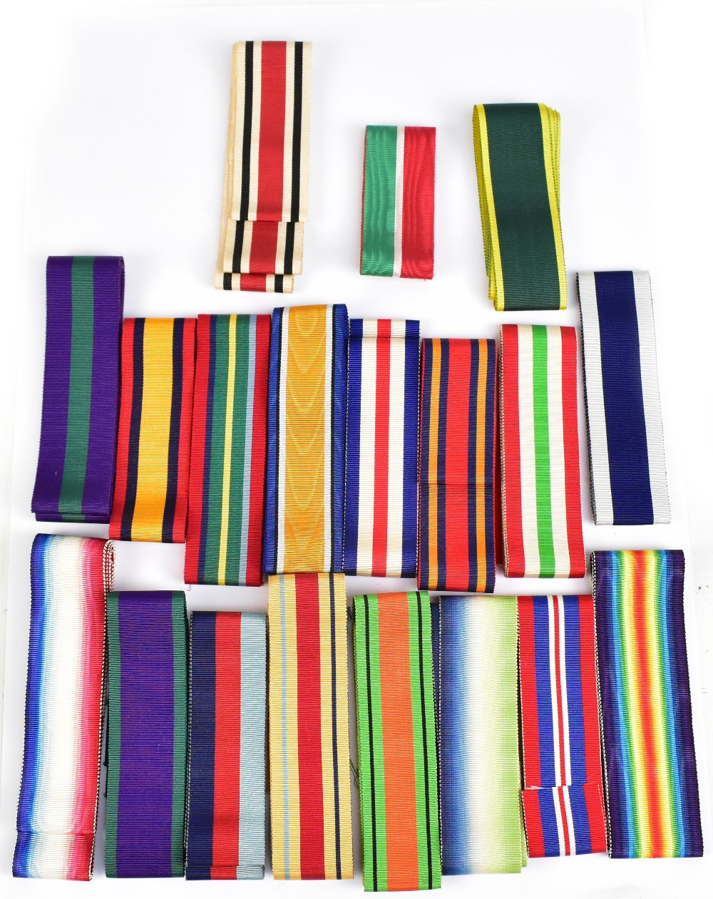 A large collection of medal ribbons, approximately nineteen different variations and various