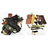 A group of military equipment including a leather gun holster, belts, gun sleeves, a leather case