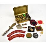 A group of militaria with cap badges including RA and RAFC, buttons, cloth badges and flashes