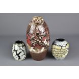 STEPHEN FREEDMAN; a stoneware vase with abstract decoration on copper red ground and two smaller