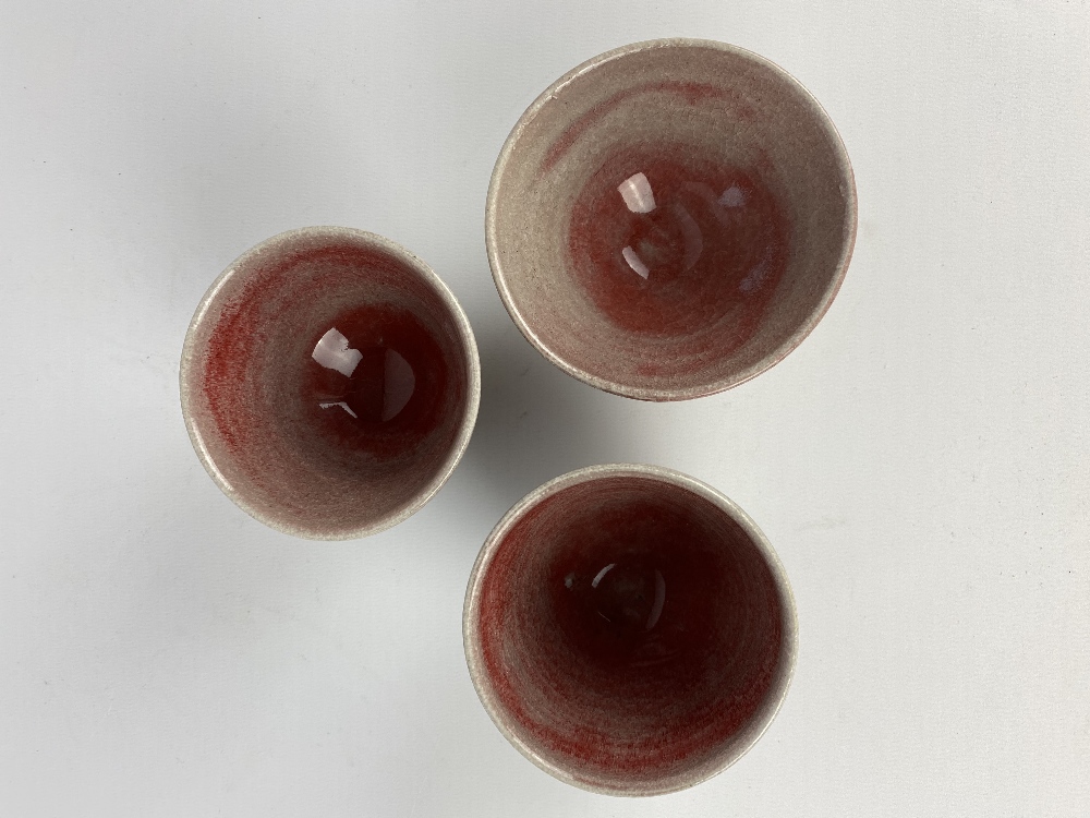 CLAYTON AMEMIYA; a group of three stoneware sake cups washed in copper red glaze, incised CA - Image 5 of 6
