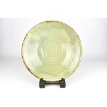 SUSAN GOLD; a large stoneware dish with celadon glaze to the well, incised signature and dated 2010,