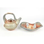 ADAM HELENSKE; a salt glazed teapot and a footed dish, incised signature to teapot, height 19.5cm (