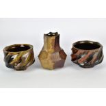 DAVID CARADORI (born 1959); a small faceted wood fired stoneware bottle and a pair faceted cups,