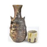 BRENDAN FULLER; a lugged wood fired stoneware bottle with heavily textured surface and a cup,