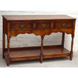 A reproduction oak dresser base with three drawers above under-tier on turned supports, height 89cm,