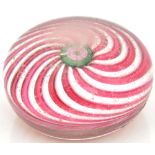 CLICHY: a glass paperweight internally decorated with a central rose inside a pink and clear swirl