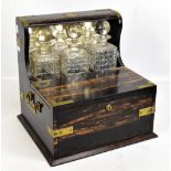 A 19th century brass bound coromandel tantalus/gaming box housing three hobnail cut glass decanters,