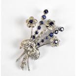 An unmarked white metal, diamond and sapphire floral spray brooch, 5.2 x 3.6cm, approx 11.5g.