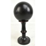 A mid 20th century ebonised ball on turned wooden stand, diameter of ball approx 11cm, overall