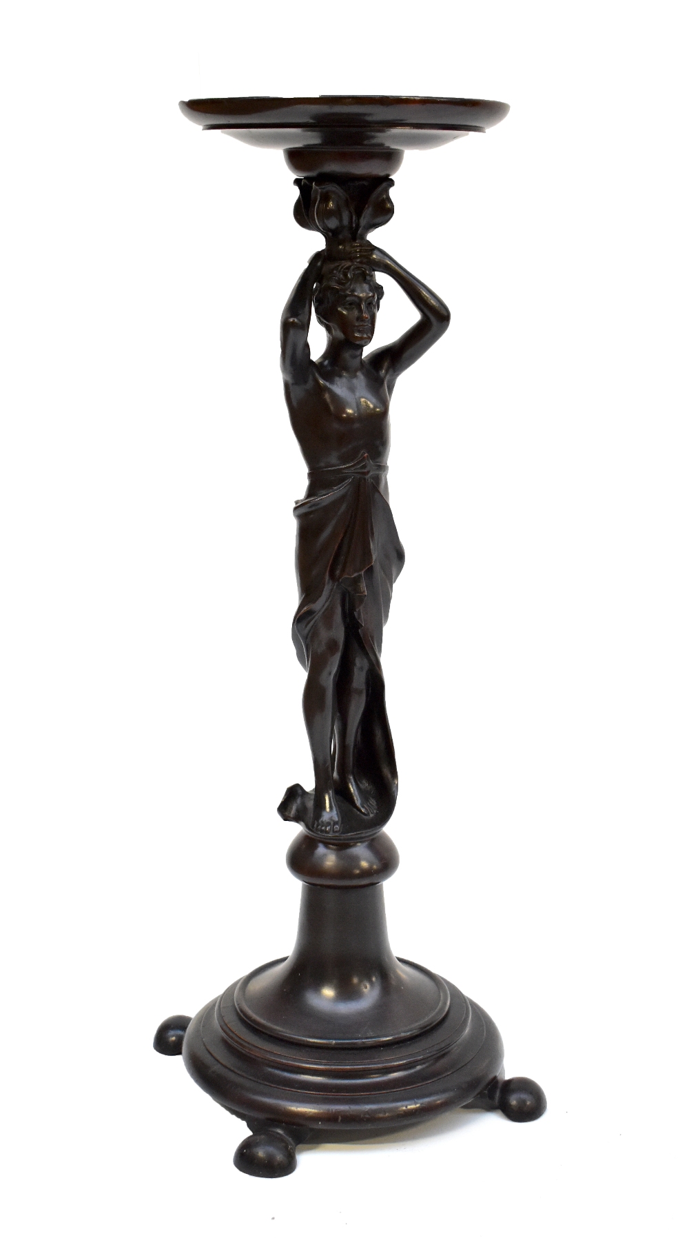 A stained and carved oak figural jardiniere stand modelled as a semi-nude figure supporting the