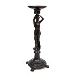 A stained and carved oak figural jardiniere stand modelled as a semi-nude figure supporting the