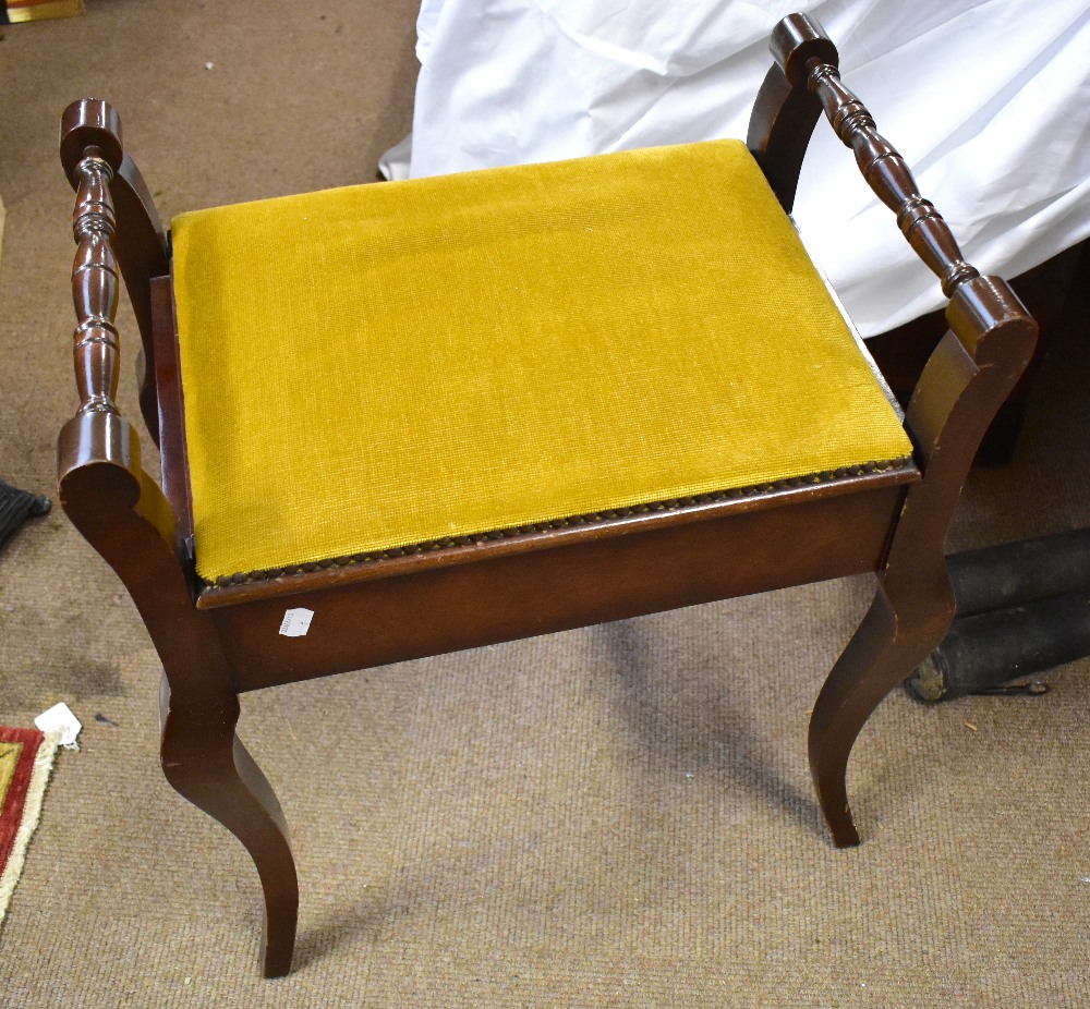 An Edwardian mahogany piano stool with hinged seat enclosing storage compartment on cabriole