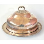 A silver plated meat dish, the associated domed cover with armorial device and motto 'TE FAVENTE