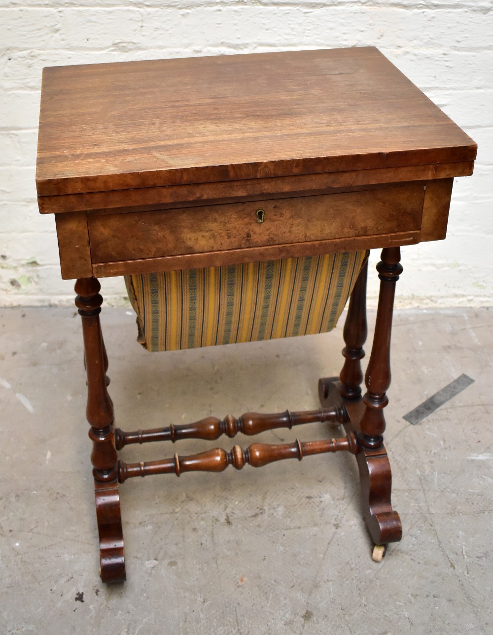 A Victorian burr walnut veneered fold-over games/sewing table, the hinged lid enclosing inlaid chess