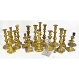 A group of brass candlesticks, two with relief foliate detail, the taller height 24.4cm, and a