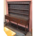 An 18th century oak dresser with plate rack back, the plate rack with eleven iron hooks above two
