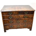 An 18th century oyster veneered low chest of four short over two long drawers, raised on bracket