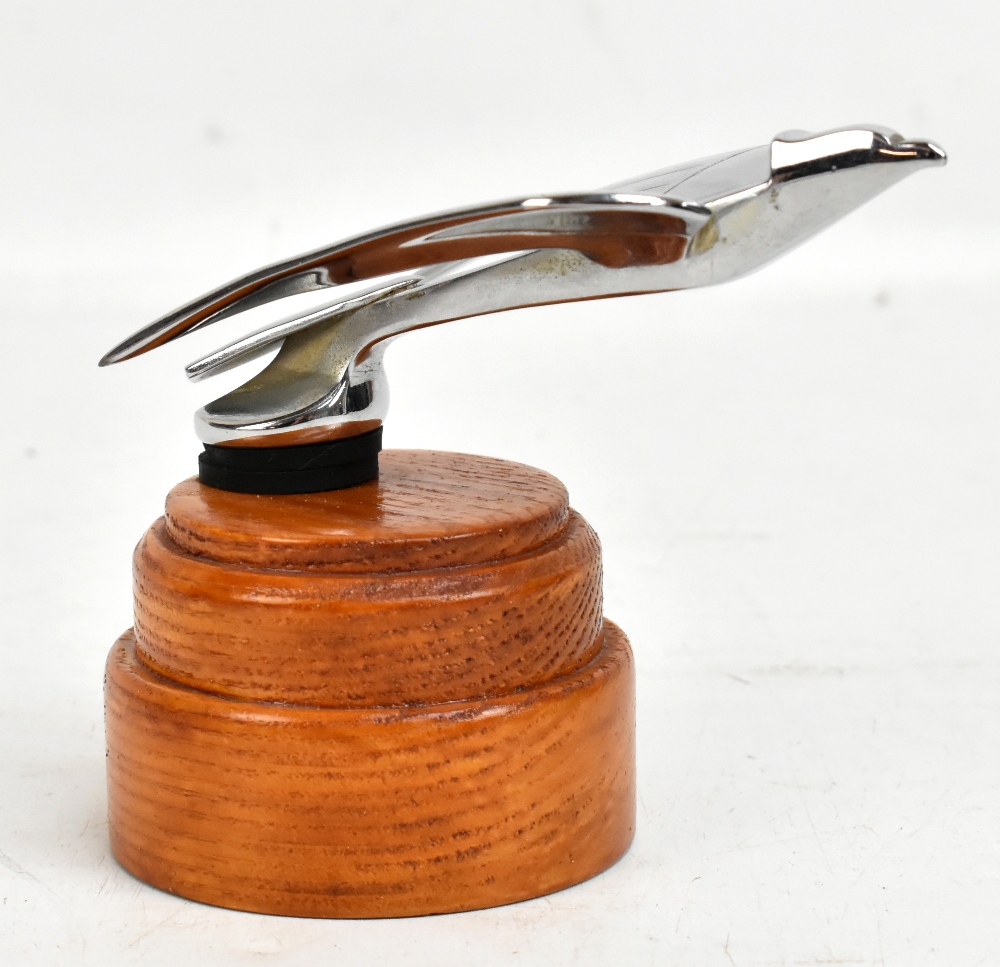 An Art Deco style chrome car mascot modelled as a stylised swallow, raised on wooden plinth base,