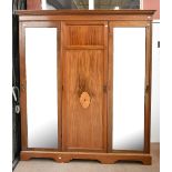 An Edwardian mahogany and boxwood strung triple wardrobe with moulded dentil cornice above two