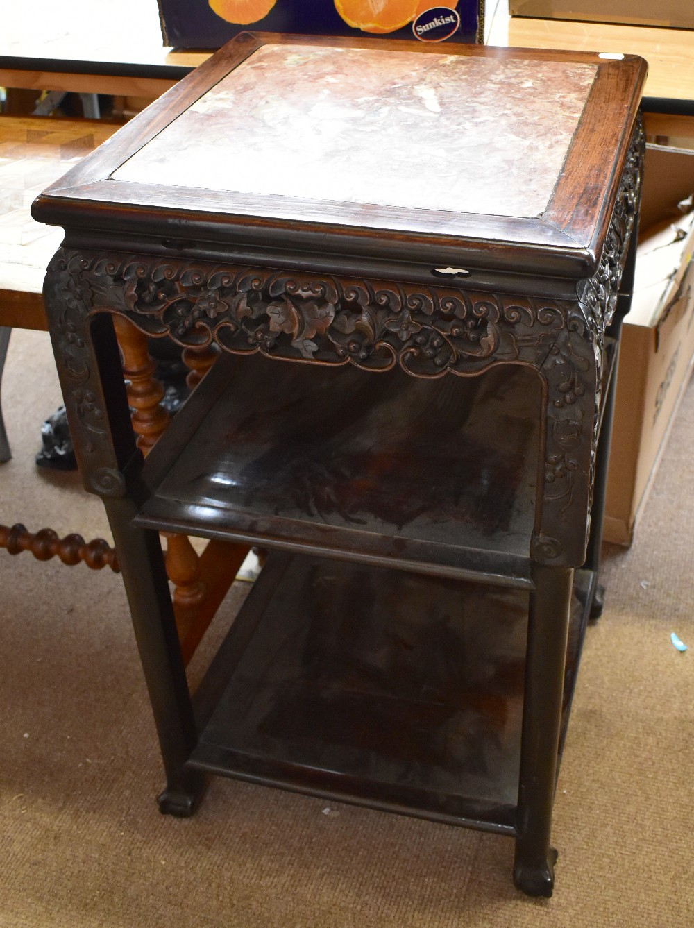 A 19th century Chinese rosewood table with inset marble top above carved and pierced floral