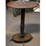 A mahogany and stained beech two tiered occasional table with oval top on fluted central stem and