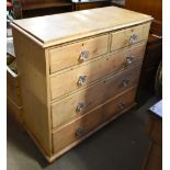 A 19th century waxed pine chest of two short over three long drawers, with glass handles, raised
