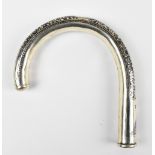 A late 19th/early 20th century white metal and niello parasol handle of arched form with floral