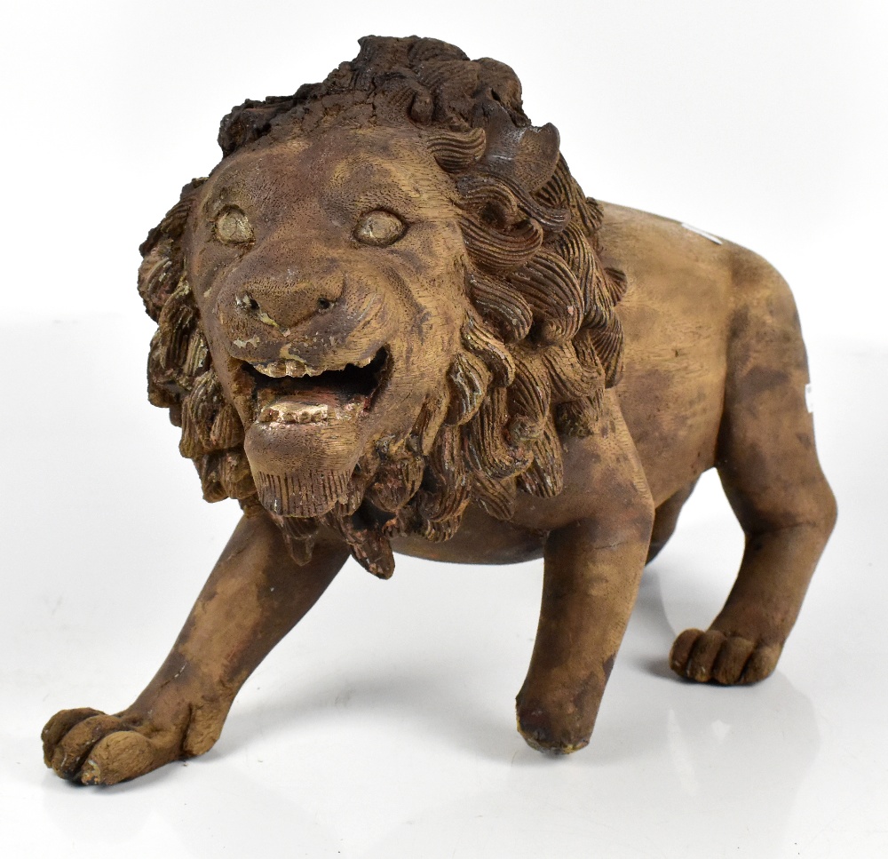 A carved treen model of a stalking lion, height 32cm, length 58cm (af).Additional InformationLarge