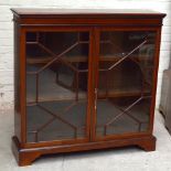 An Edwardian inlaid mahogany bookcase, the twin astragal glazed doors enclosing two adjustable