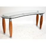 AFTER CHRISTIAN STOCKER; a kidney-shaped glass topped table/desk on turned wooden legs, width