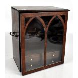 A 19th century mahogany table top cabinet, the single glazed door enclosing two drawers, with swan