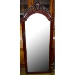 A reproduction mahogany cheval mirror with pierced cornice, the frame raised on ball and claw