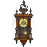 An early 20th century Vienna style wall clock with carved horse surmount, the circular dial set with