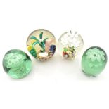 Four Victorian and later glass paperweights to include two dumps with internal floral decoration,
