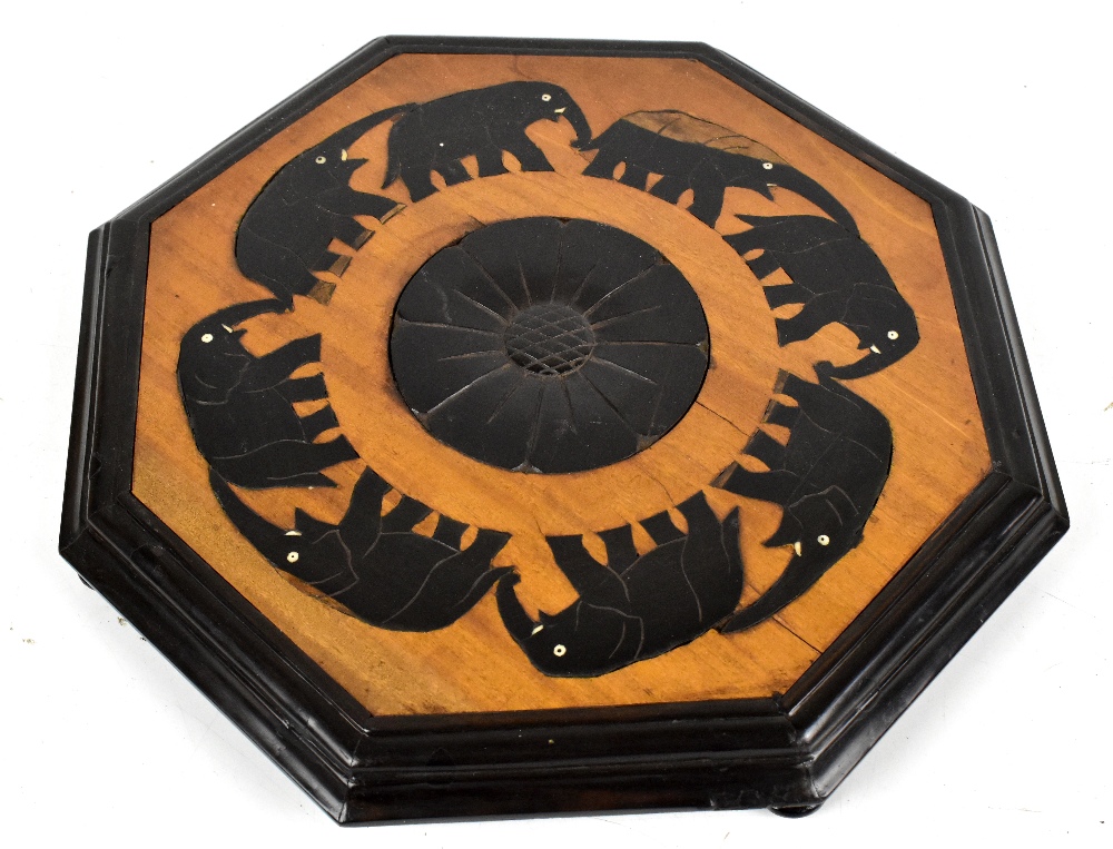 An early 20th century Anglo-Indian octagonal stand with carved and inlaid detail depicting an