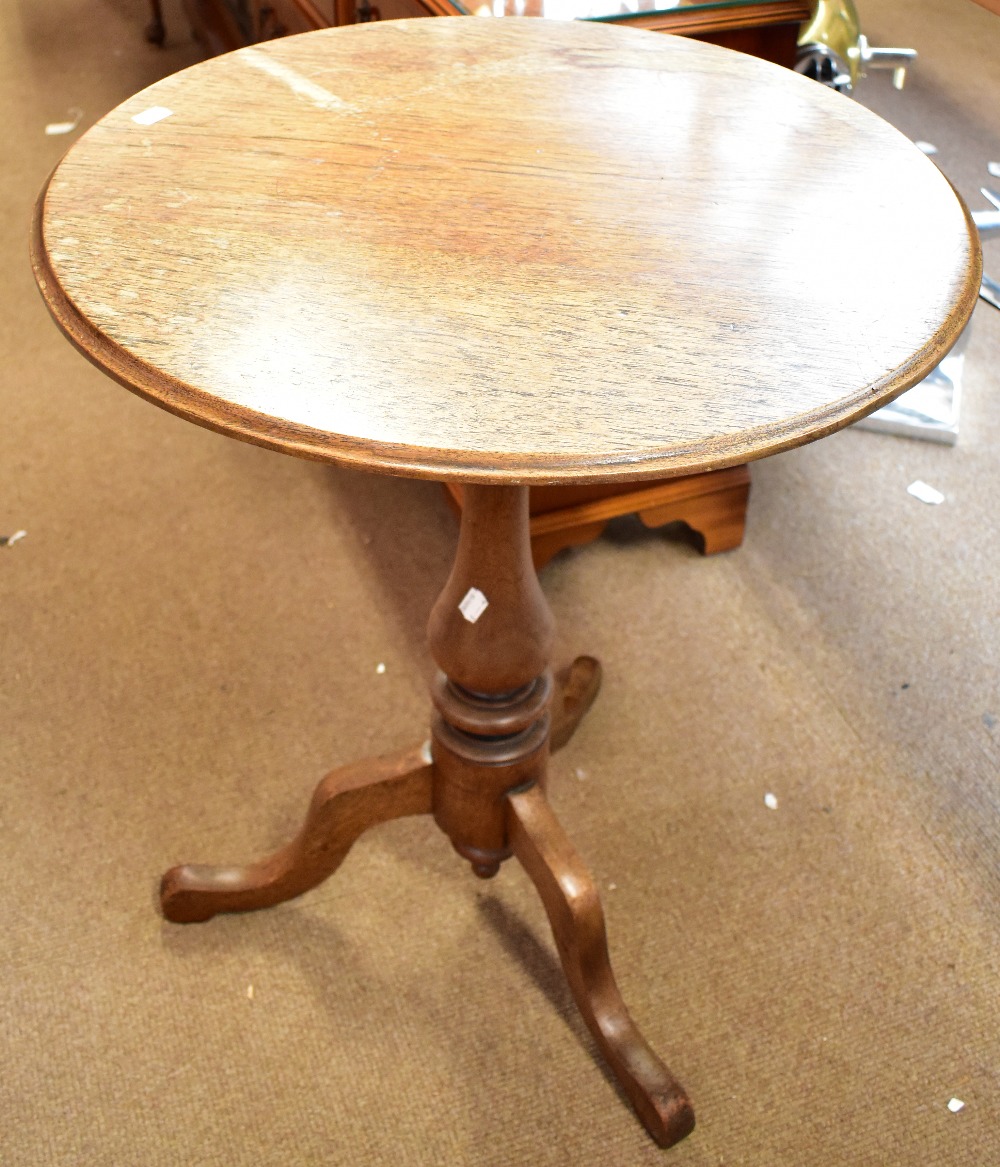 A 19th century oak tripod table on outswept supports, height 69.5cm, diameter 57cm.Additional