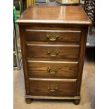 REPRODUX; a reproduction narrow oak chest of four drawers, raised on bun feet, height 69cm, width