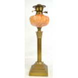 A late 19th/early 20th century brass Corinthian column oil lamp, the glass reservoir with moulded