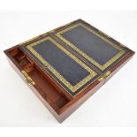 An early 19th century rosewood campaign writing slope with recessed brass side handles, gilt