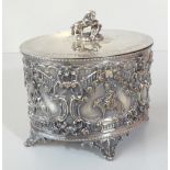 A Victorian oval silver plated biscuit box with repoussé decoration of cherubs riding sheep on