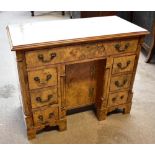 A reproduction burr walnut veneered knee hole desk with single long drawer above six short drawers