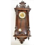 A late 19th century Vienna wall clock with carved eagle surmount, the circular dial set with Roman