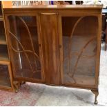 A mid-20th century mahogany display cabinet, the twin glazed doors enclosing two adjustable shelves,
