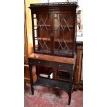 A mahogany cabinet on stand with galleried cornice and blind fret detail above twin astragal