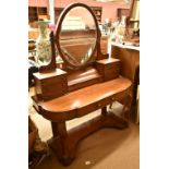 A Victorian mahogany dressing table with oval mirror above arrangement of seven drawers, the