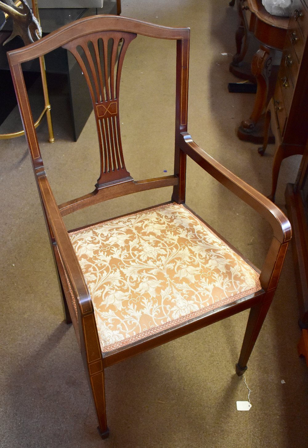 An Edwardian inlaid mahogany open arm elbow chair.