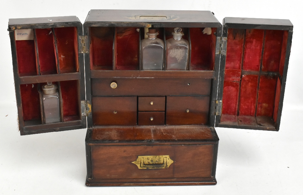 An early 19th century mahogany apothecary cabinet, the twin doors enclosing fitted compartments