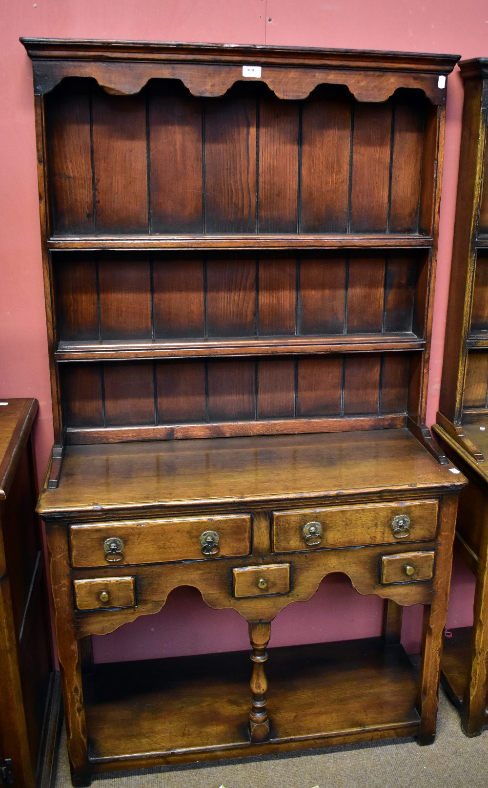 A small reproduction oak dresser, the plate rack back with two fixed shelves above an arrangement of